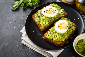 Avocado Sandwiches with Boiled Egg and Cereal Bread in black plate.