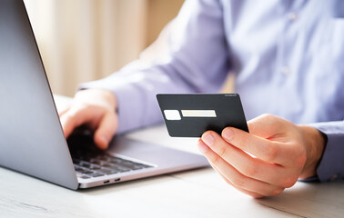 A man from home buys goods in an online store in the context of a coronavirus - A close-up of a...