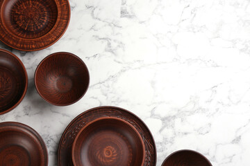Set of clay dishes on white marble table, flat lay. Space for text