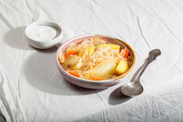 Vegetarian sour soup with sauerkraut on gray background. Comfort healthy food