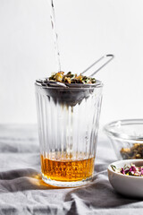 Glass of herbal tea with chamomile, rose and mint. Home remedy concept. Selective focus