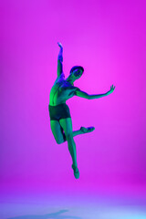 Emotions. Young and graceful ballet dancer on purple studio background in neon light. Art, motion, action, flexibility, inspiration concept. Flexible caucasian ballet dancer, moves in glow.