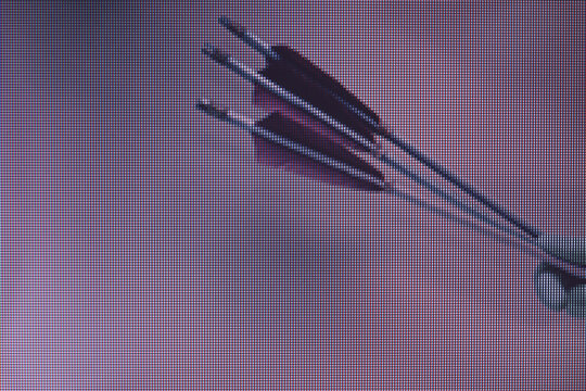 Beautiful hand holding old green arrows in the color light. Beautiful old arrow minimal in neon light. Minimalism retro style concept. Macro  photography view. Close-up of pixel.