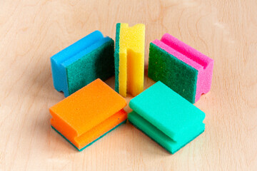 five colorful sponges on wooden background
