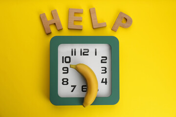 Clock with banana and word HELP on yellow background, flat lay. Potency problem concept