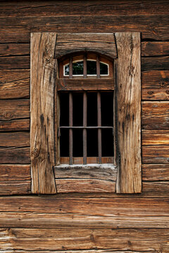 old barred window in wooden wall