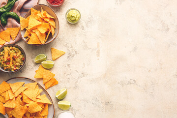 Plates with nachos and products on light background