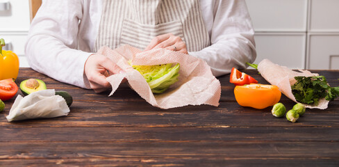 Female wrapping cheese into beeswax wraps at the kitchen