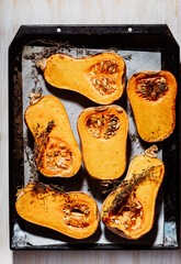 Roasted pumpkins with thyme herbs on baking sheet