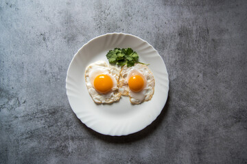 Egg poach sunny side up a healthy food ingredient on a plate. View from top, selective focus.