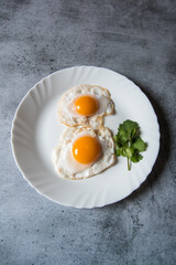 Egg poach sunny side up a healthy food ingredient on a plate. View from top, selective focus.