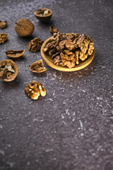Walnut in wooden bowl on black background with copy space
