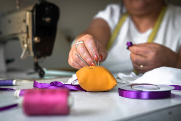 Working woman, woman sewing purple ribbon on face masks. women's Day. Gender violence
