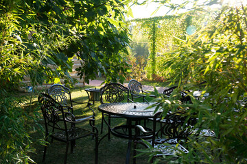 Garden chairs and table metal openwork forged in the summer garden