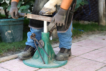 Unknown blacksmith working with a horseshoe outdoors summertime