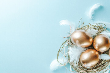 Obraz na płótnie Canvas Egg color. Happy Easter decoration: golden colour eggs in basket, white feathers on pastel blue background. Foil minimalist egg design, modern top view template.