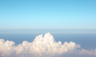 Beautiful white clouds on blue sky. View from inside airplane.