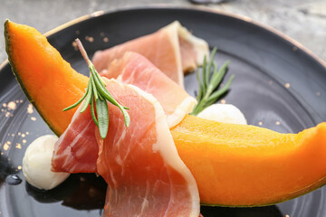 Plate with delicious melon, mozzarella and prosciutto, closeup
