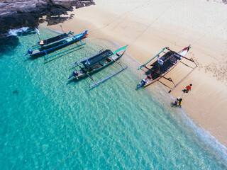 Top view of traditional wooden boat parking on the shore. Beautiful beach with crystal clear water.
