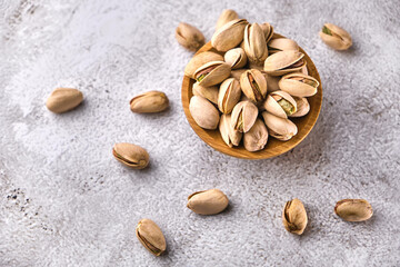 Organic pistachio nuts in bowl on table.