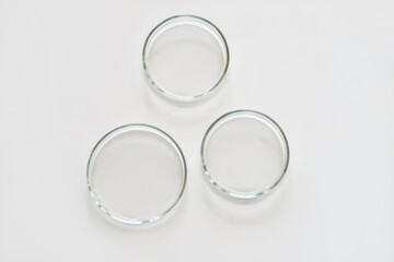 three empty glass Petri dishes on a laboratory table. sterile lab dishes ready for tests. analysis and chemical experiment. cell culture growing equipment. top view.