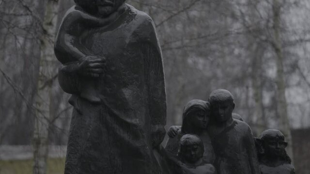 A concrete\stone monument inside a Jewish cemetery while raining. the camera moves slowly over the statue's details in a telephoto lens, a 4K (Sony S-Log) clip, Warsaw, Poland.