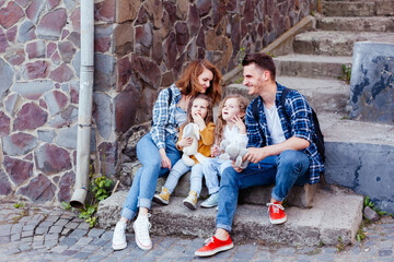 the young family are resting while walking the old city