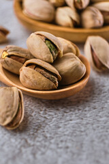 Organic pistachio nuts in bowl on table.