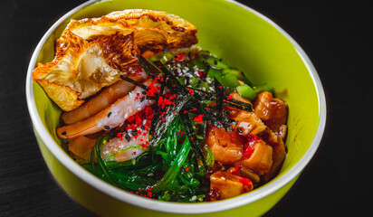 Fresh seafood recipe. Shrimp salmon poke in bowl on black wooden table background