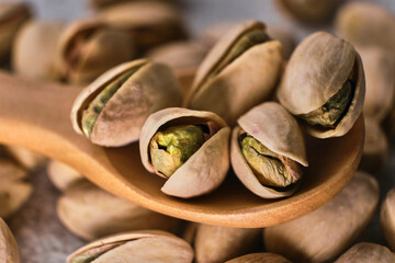Organic pistachio nuts in bowl on table.