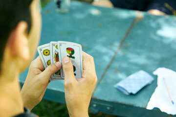 Personas Latinoamericanas jugando a las cartas de truco al aire libre. Familia jugando