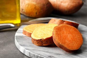 Composition of fresh sliced sweet potatoes on a marble background close-up.