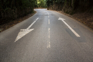 Direction arrows on empty asphalt road