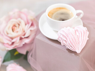 Coffee in a white cup and homemade zefir, marshmallows on a light background. Top view with copy space for your text.