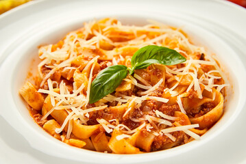 Pasta spaghetti bolognese. Traditional italian dish of pasta with tomato and meat mince sauce served in a plate with parmesan cheese and basil, top view