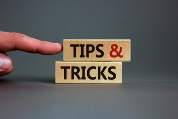 Tips and tricks symbol. Wooden blocks with words 'Tips and tricks'. Beautiful grey background....