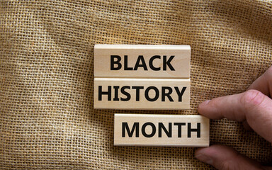 Black history month symbol. Wooden blocks with words 'Black history month'. Beautiful canvas background. Man hand. Black history month concept. Copy space.
