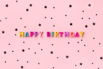 Happy birthday inscription from wooden colorful letters with confetti