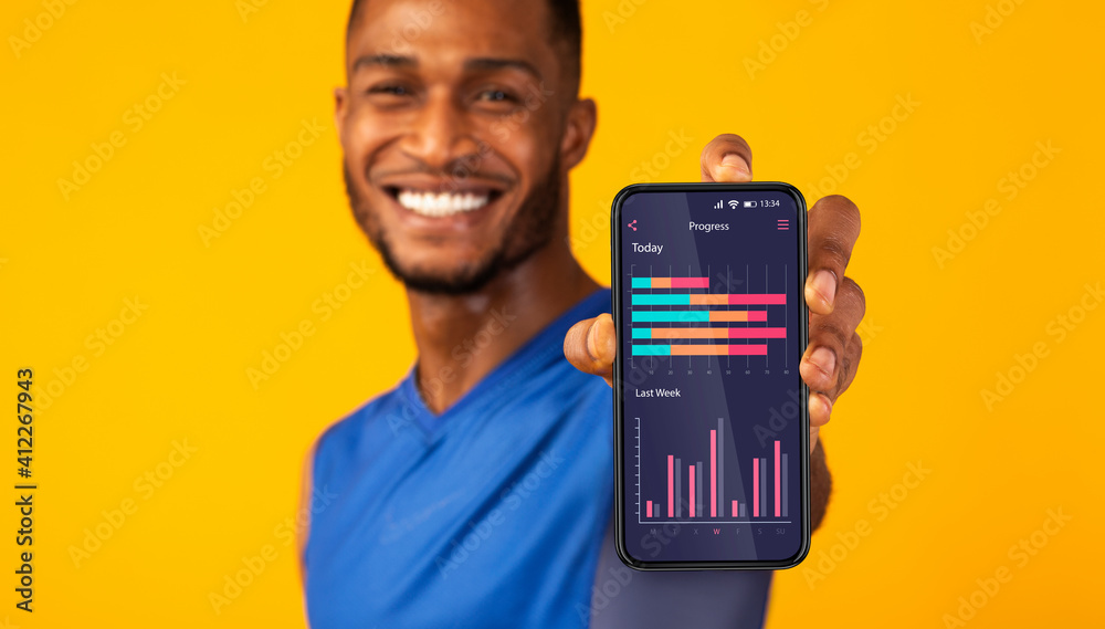 Aufkleber cheerful black man demonstrating application on smartphone screen with sport activity progress
