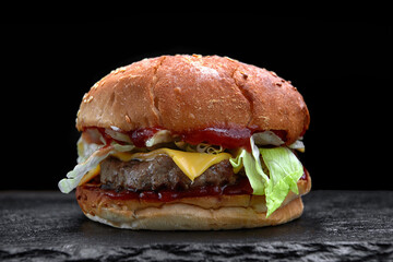 Burger, cheeseburger, hamburger with meat cutlet, cheese, lettuce and tomato, on a black background