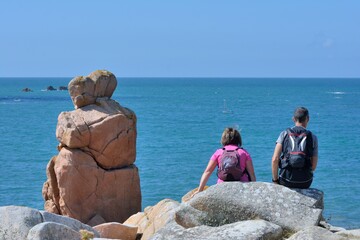 Couple of people and couple in rock in front of the sea in Brittany. France