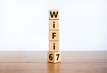 WiFi 6 or 7 symbol. Turned a wooden cube and changed the words WiFi 6 to WiFi 7. Beautiful wooden table, white background, copy space. Business, technology and WiFi 6 to WiFi 7 concept.