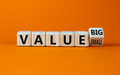 Small or big value symbol. Turned wooden cubes and changed words 'value small' to 'value big'. Beautiful orange background, copy space. Business and small or big value concept.