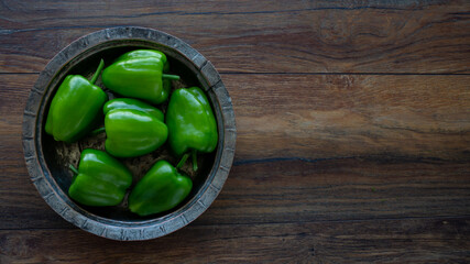 Food background. Green bell peppers on the wooden table.