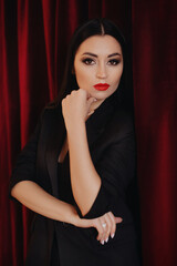 Photo of beautiful young brunette woman with red lips in a casual black clothes