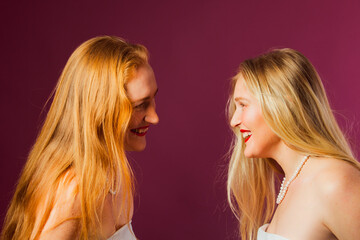 Two women standing opposite each other, touching by heads