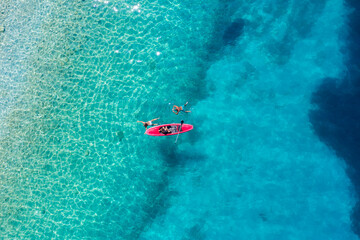 Kayaking. Sup. Aerial view of floating board and people on blue sea at sunny day. Travel and active...