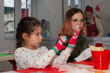 Two girls take part in a master class on making caramel.