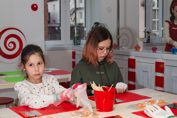 Two girls take part in a master class on making caramel.