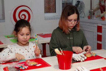Two girls take part in a master class on making caramel.